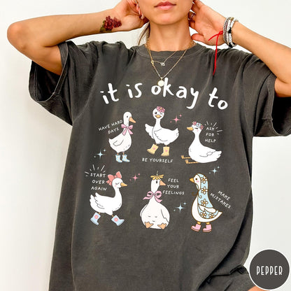 Comfort Colors tee in Pepper featuring whimsical graphic style with six cute geese and motivational text phrases