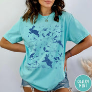 Comfort Colors tee in Chalky Mint featuring celestial design style with jumping bunnies and planets graphic print