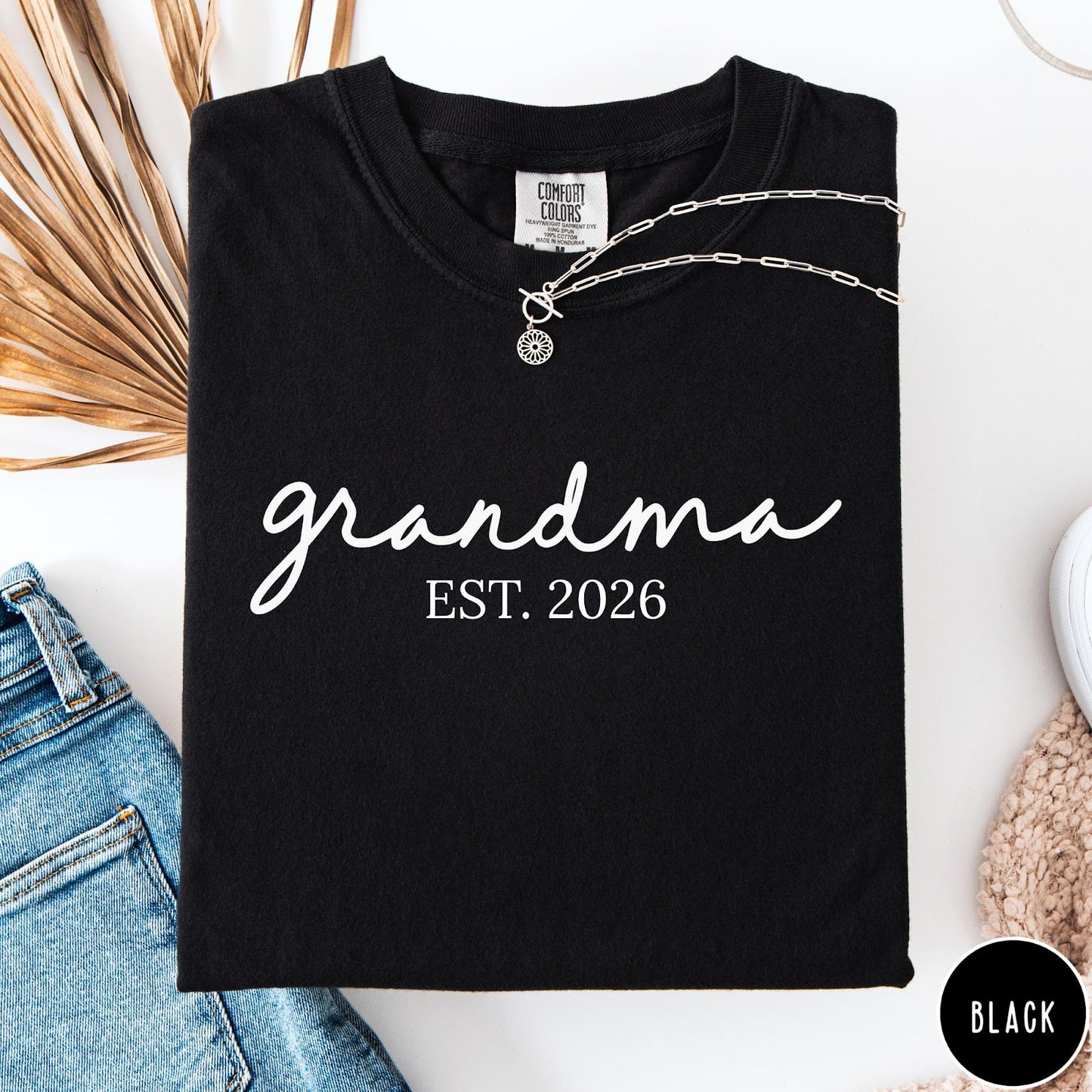 Comfort Colors tee in Black featuring script design Grandma Est. 2026 announcement graphic in white