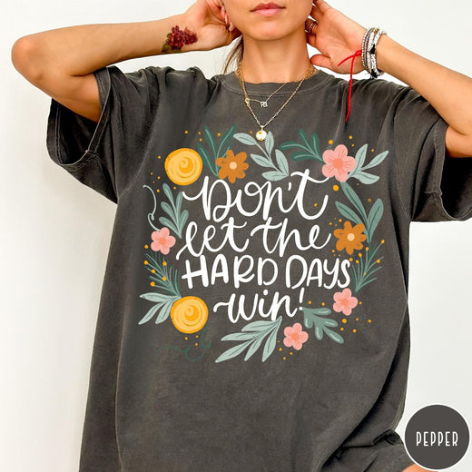Comfort Colors tee in Pepper featuring floral design with mental health encouragement text Don't Let The Hard Days Win