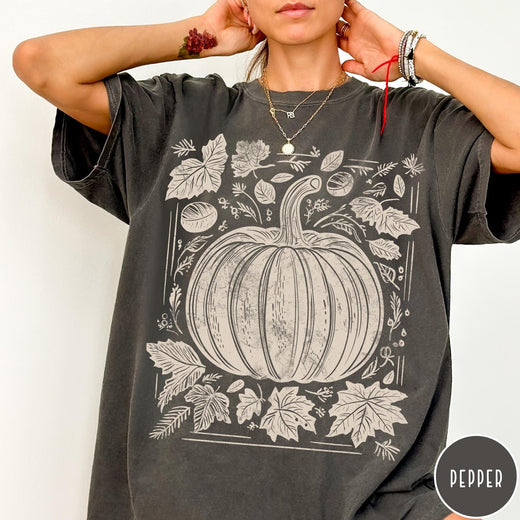 Comfort Colors tee in Pepper featuring rustic pumpkin design with surrounding fall leaves and woodland elements