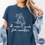 Comfort Colors tee in Midnight featuring line art graphic of a duck wrapped in a blanket drinking coffee