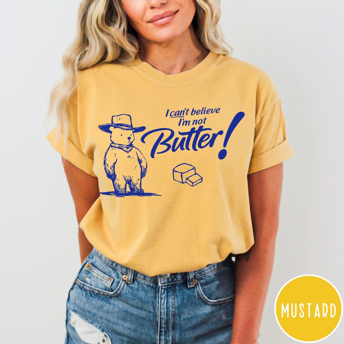 Comfort Colors tee in Mustard featuring bear graphic with cowboy hat and text I can't believe I'm not Butter
