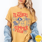 Comfort Colors tee in Mustard featuring summer vacation graphic with beach umbrella, palm tree, and beach chair.