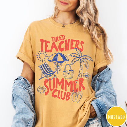 Comfort Colors tee in Mustard featuring summer vacation graphic with beach umbrella, palm tree, and beach chair.