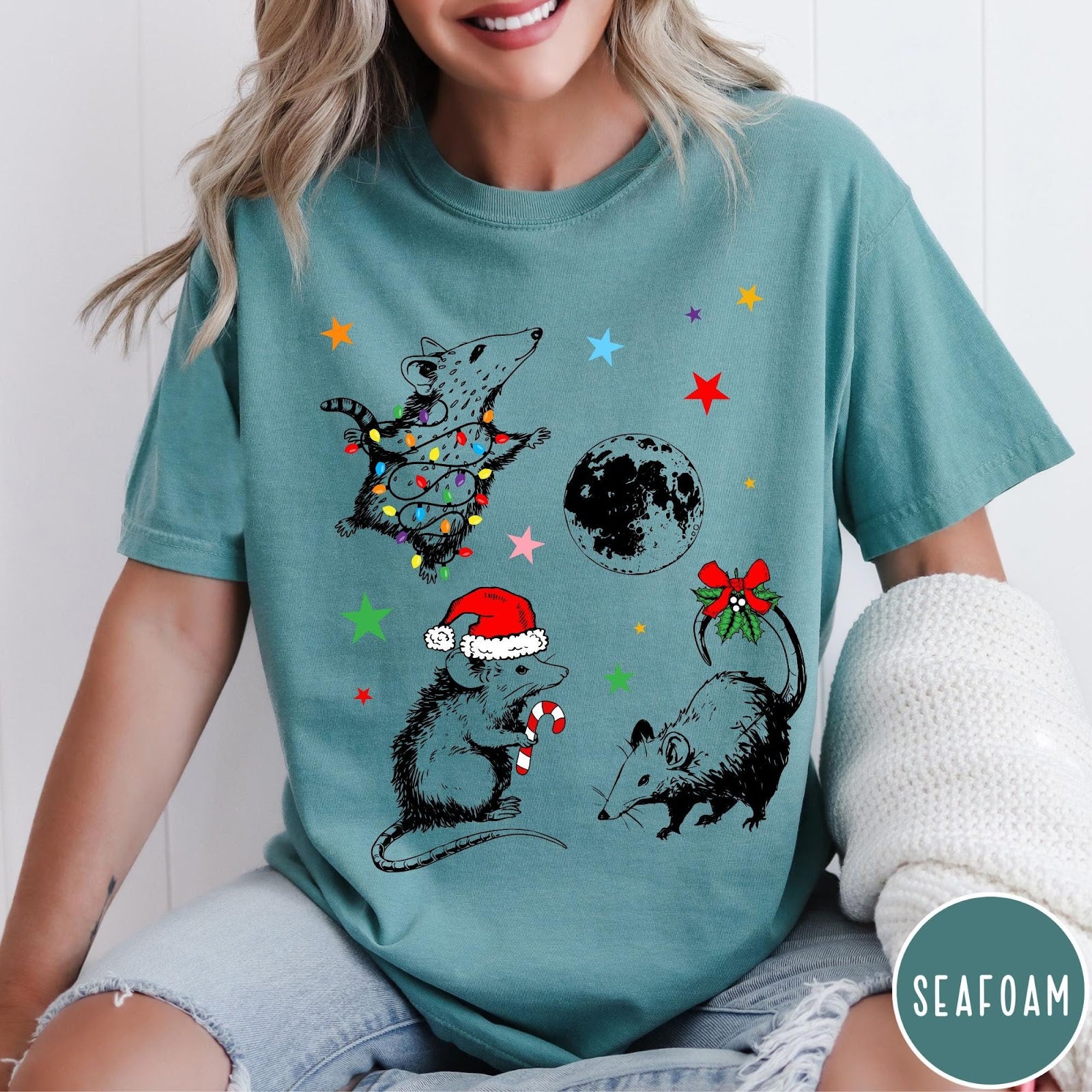Comfort Colors tee in Seafoam featuring holiday possum graphic with Christmas lights, candy cane, and moon.