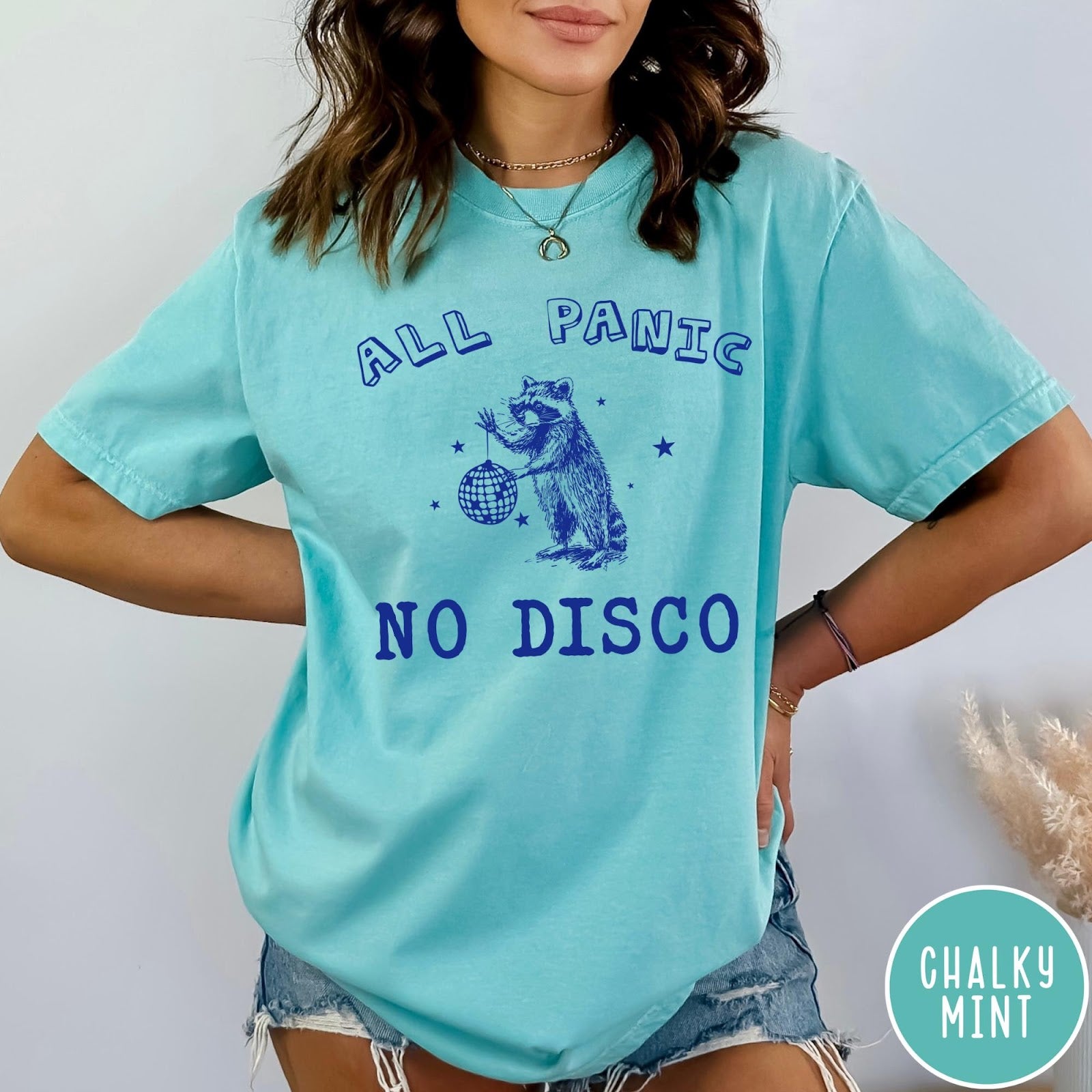 Comfort Colors tee in Chalky Mint featuring screen printed raccoon graphic holding a disco ball with star accents