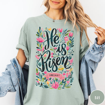 Comfort Colors tee in Bay featuring Easter religious floral graphic with He is Risen and Luke 24:6-7 text