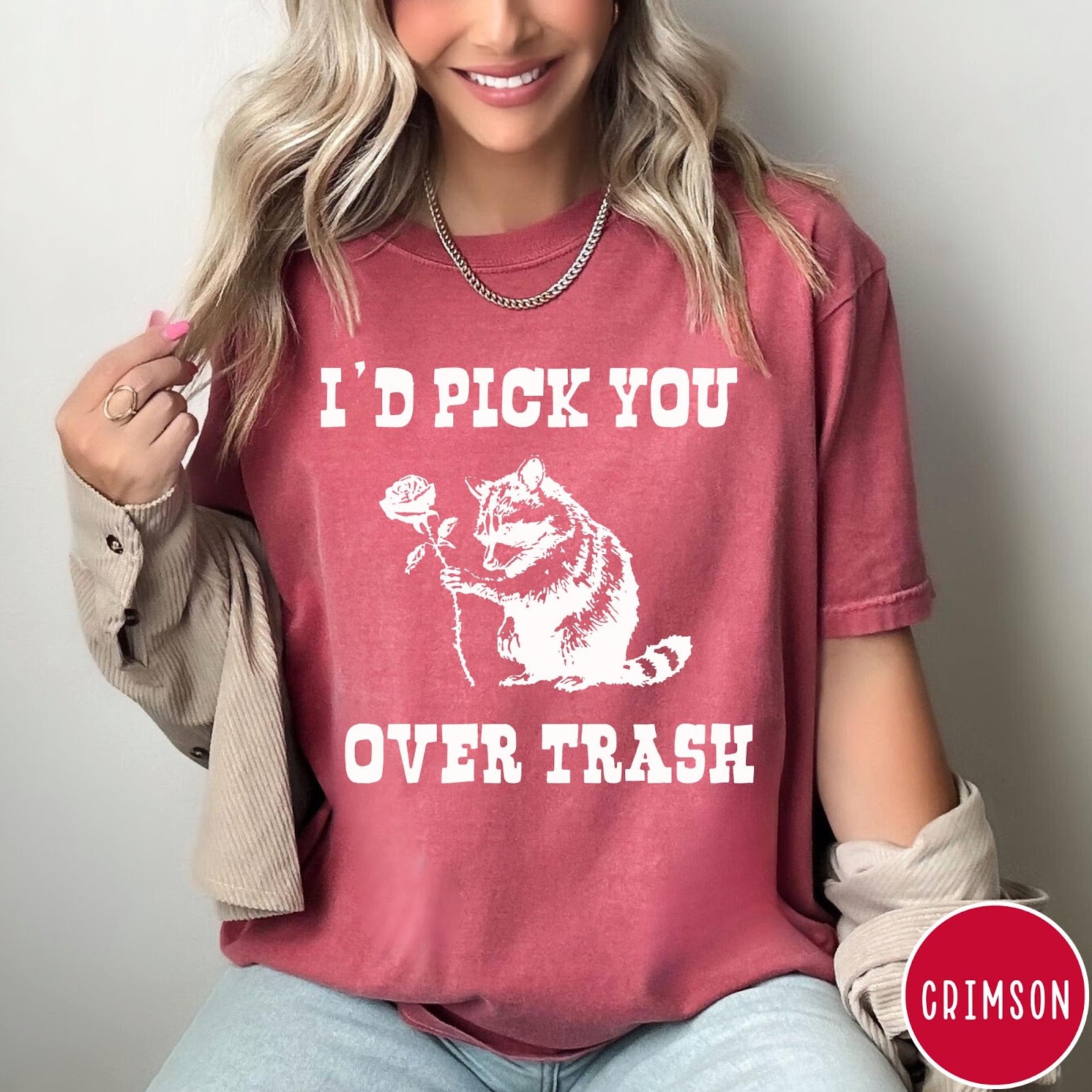 Comfort Colors tee in Crimson featuring a whimsical graphic of a raccoon holding a white rose.