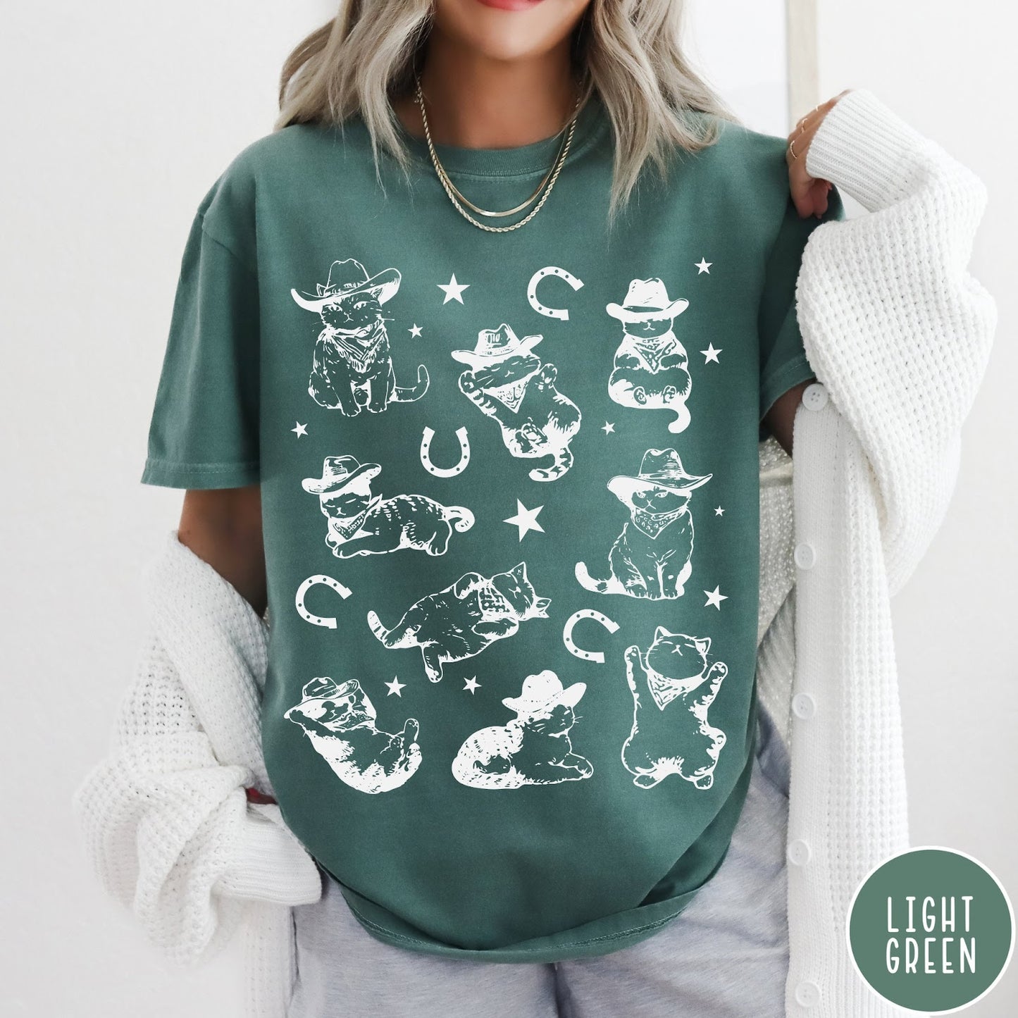 Comfort Colors tee in Light Green featuring western graphic style with multiple cowboy kittens and horseshoe illustrations