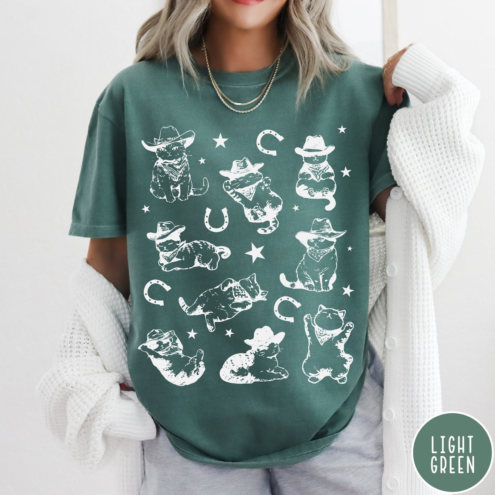 Comfort Colors tee in Light Green featuring western graphic style with multiple cowboy kittens and horseshoe illustrations