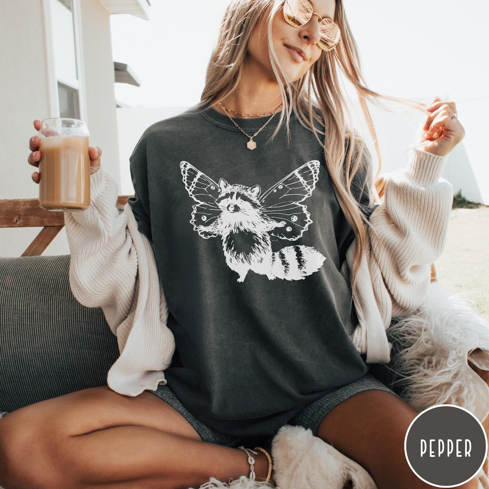 Comfort Colors tee in Pepper featuring whimsical graphic style of a raccoon with large detailed butterfly wings