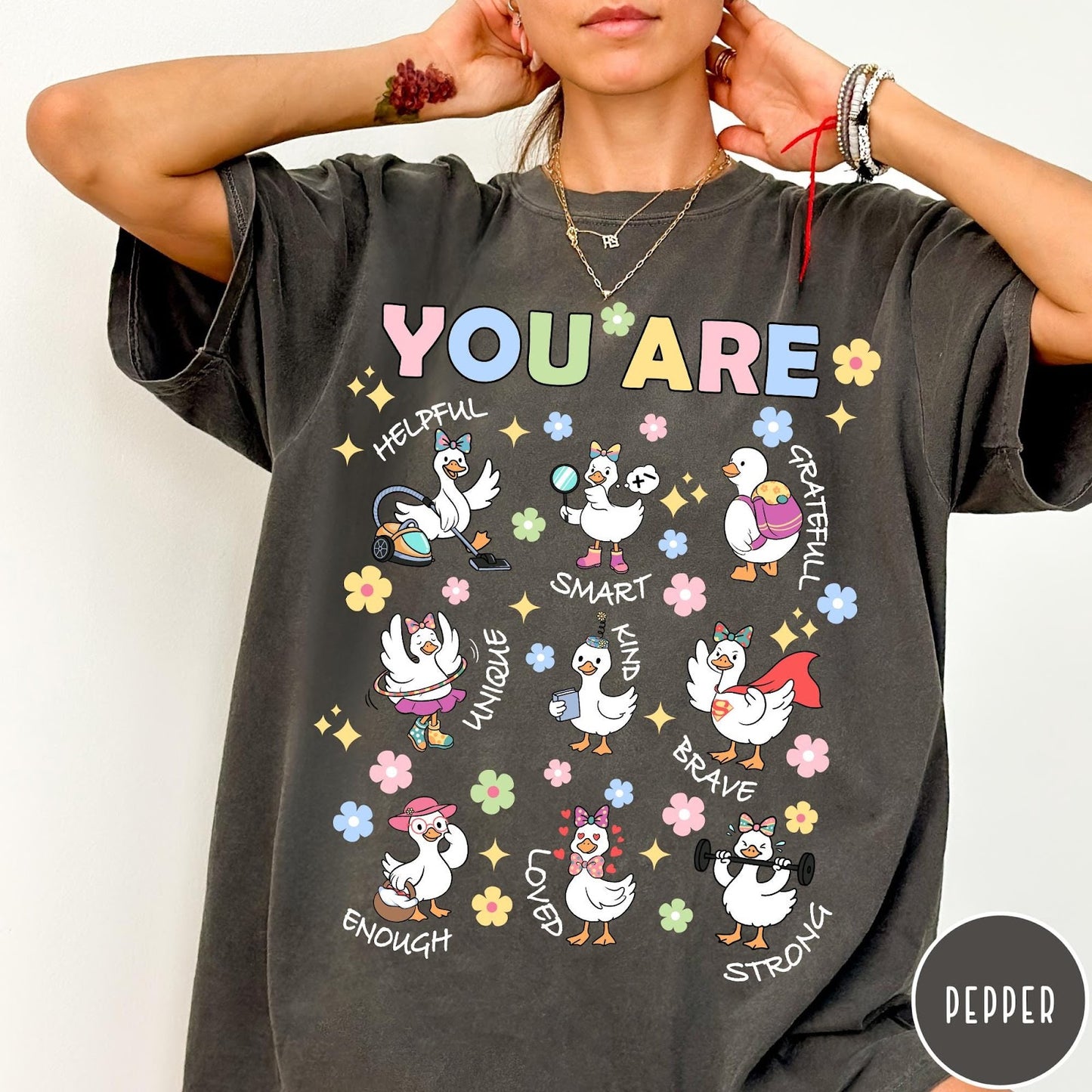 Comfort Colors tee in Pepper featuring cute cartoon duck graphic with inspirational words like kind and brave
