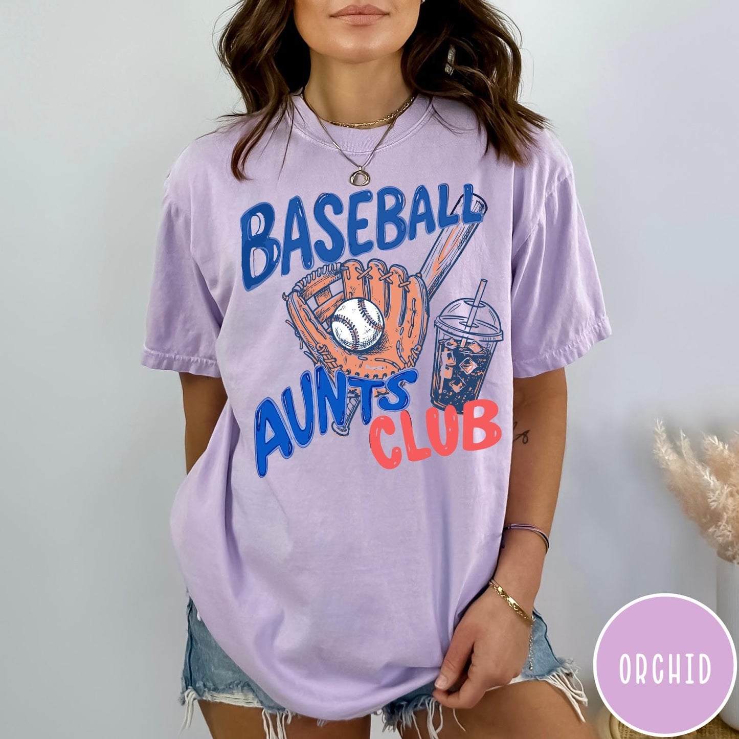 Comfort Colors tee in Orchid featuring baseball graphic with a mitt, ball, bat, and iced coffee drink
