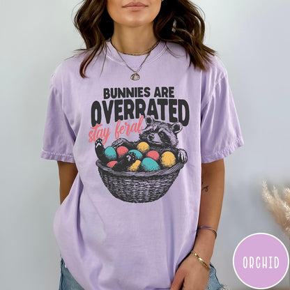 Comfort Colors tee in Orchid featuring graphic illustration of a raccoon sitting in an Easter basket
