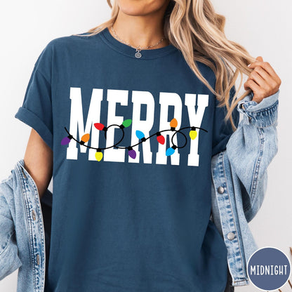 Comfort Colors tee in Midnight featuring festive holiday style graphic with Merry text and Christmas lights
