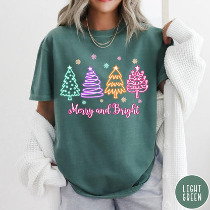 Comfort Colors tee in Light Green featuring neon Christmas tree graphic with Merry and Bright text and snowflakes