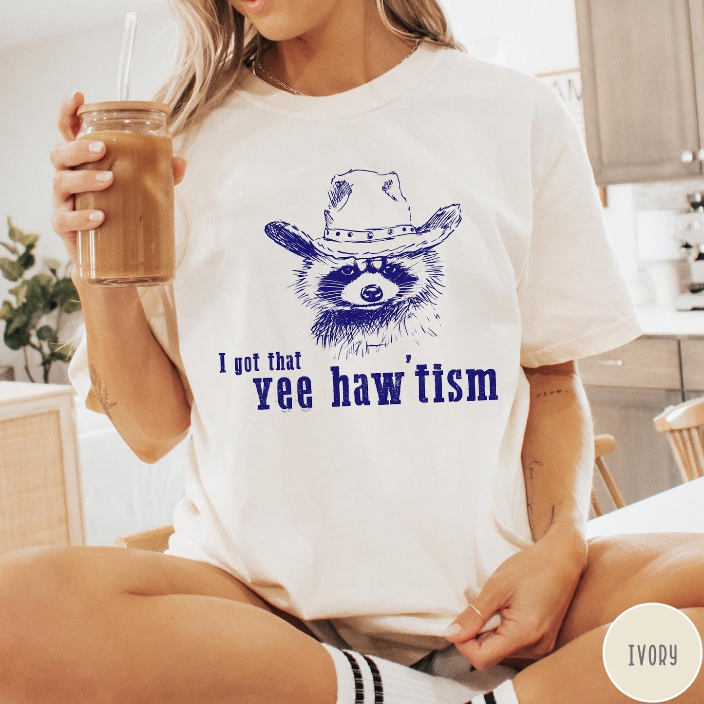 Comfort Colors tee in Ivory featuring western style graphic of a raccoon wearing a cowboy hat