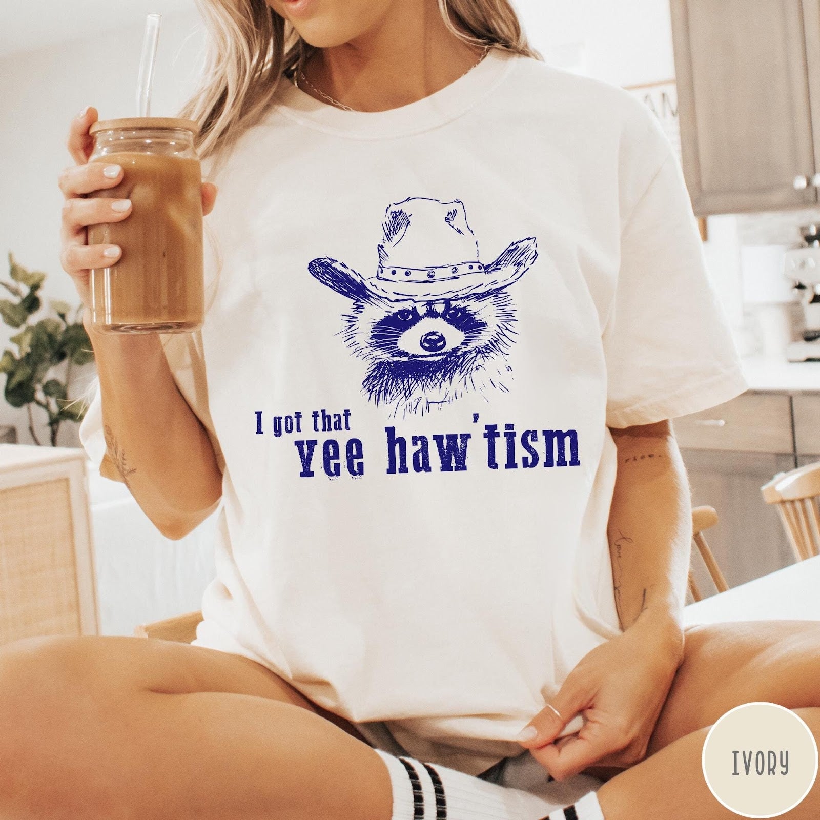 Comfort Colors tee in Ivory featuring western style graphic of a raccoon wearing a cowboy hat