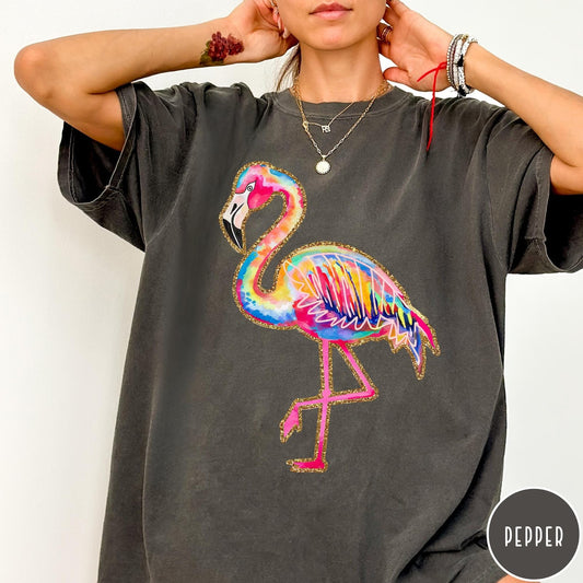 Comfort Colors tee in Pepper featuring artistic watercolor flamingo graphic with gold glitter outline details
