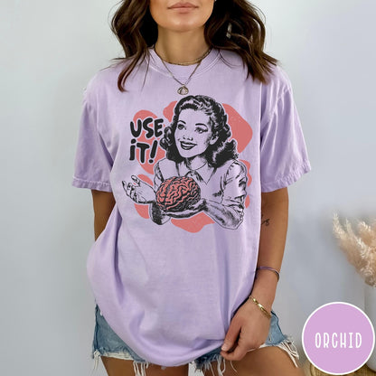 Comfort Colors tee in Orchid featuring retro style graphic of a woman holding a human brain