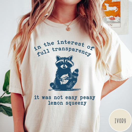 Comfort Colors tee in Ivory featuring screen printed raccoon graphic and text about full transparency and lemons