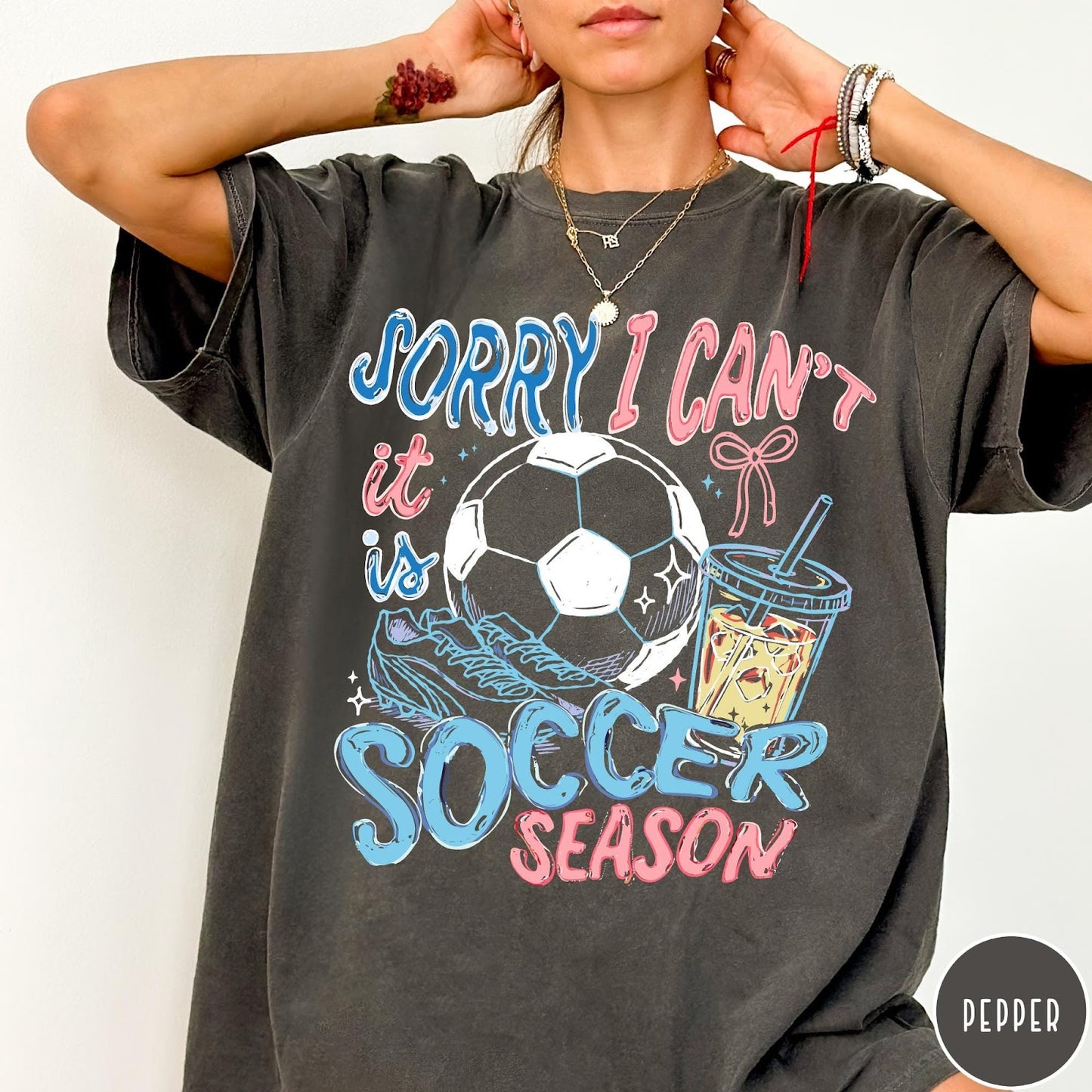 Comfort Colors tee in Pepper featuring screen print style soccer season graphic with ball and iced coffee