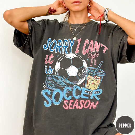 Comfort Colors tee in Pepper featuring screen print style soccer season graphic with ball and iced coffee