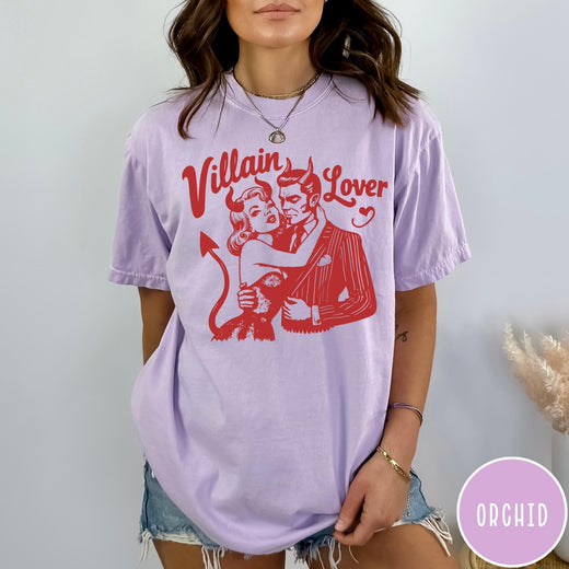 Comfort Colors tee in Orchid featuring vintage style graphic of a devilish couple embracing with red ink