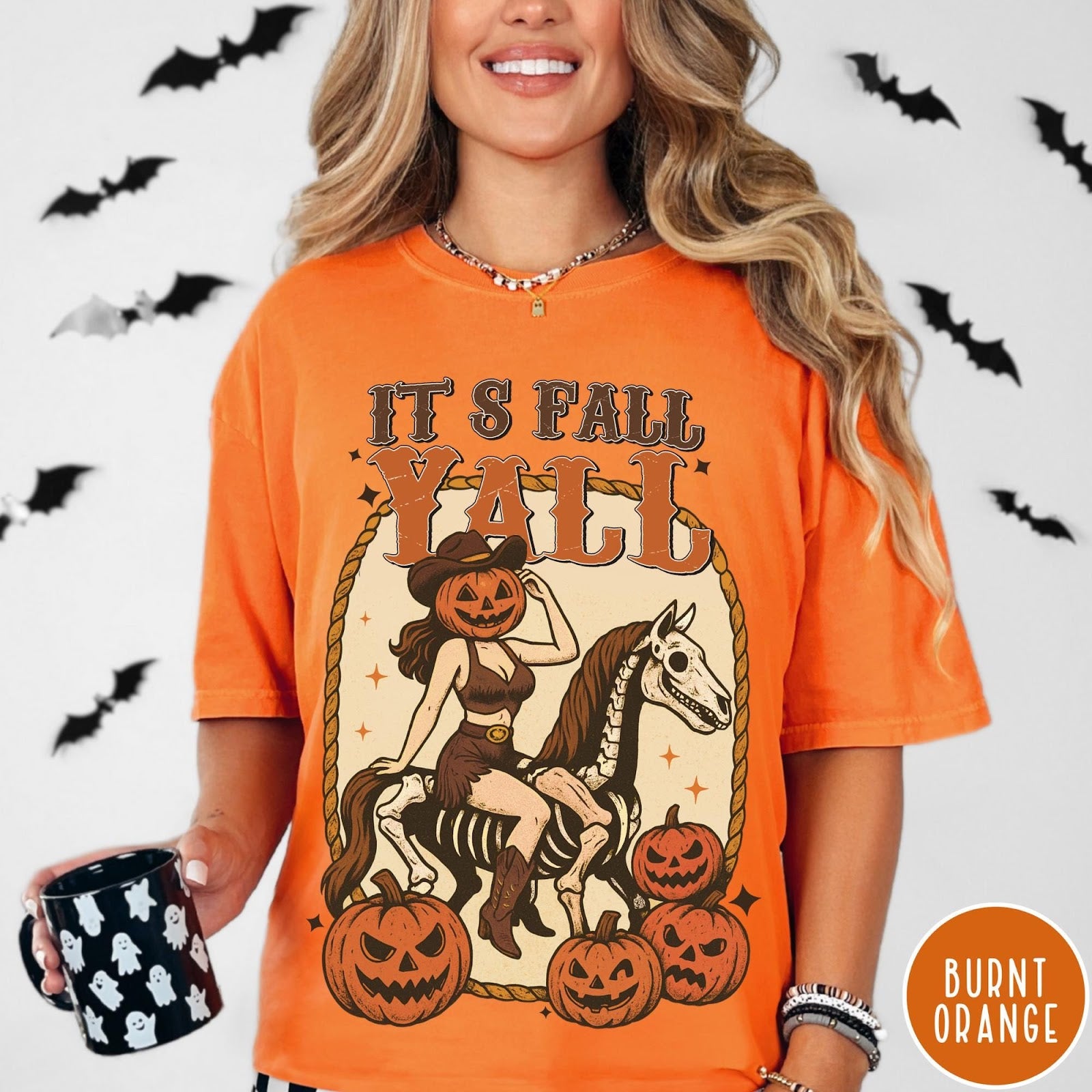 Comfort Colors tee in Burnt Orange featuring western graphic of a pumpkin cowgirl riding a skeleton horse with pumpkins