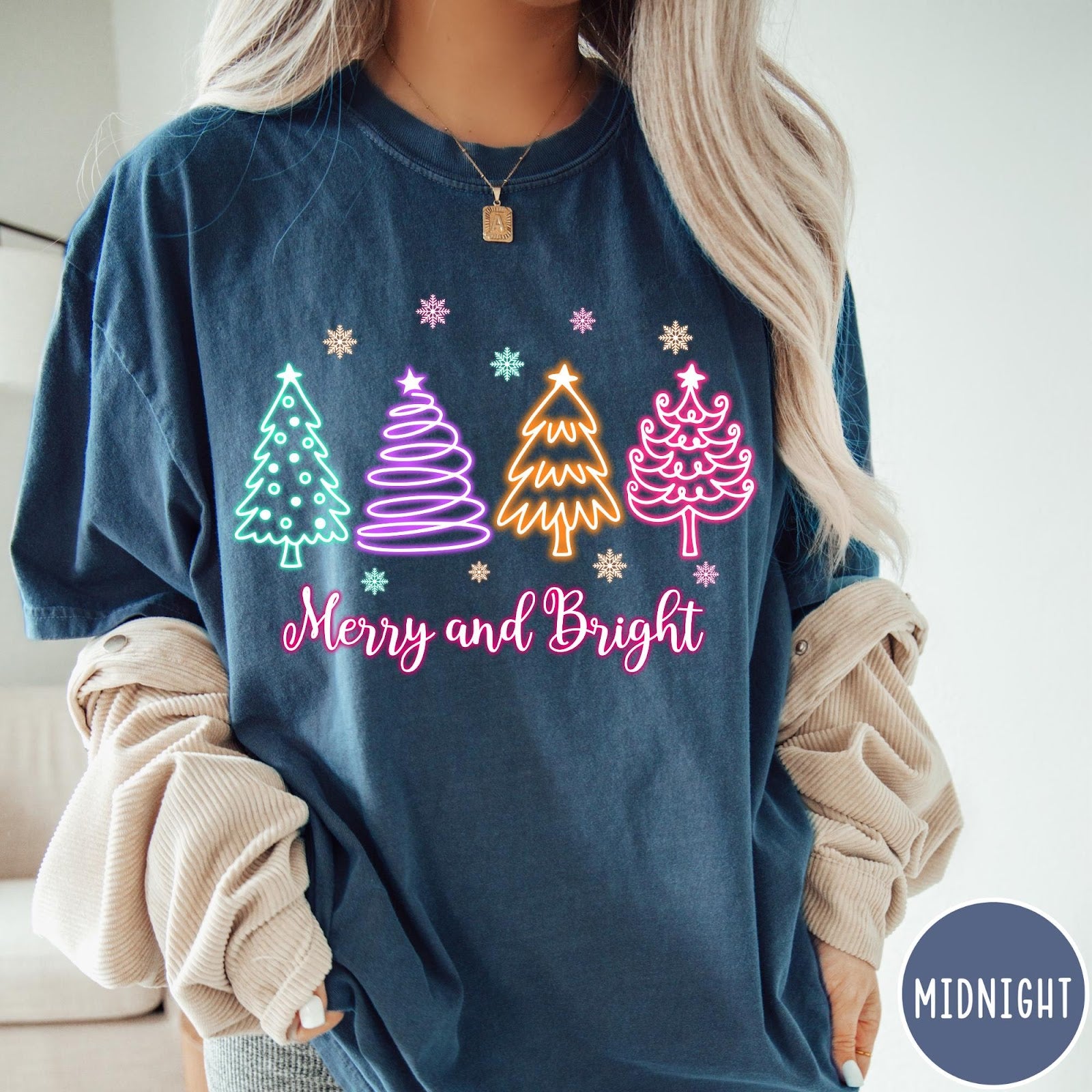 Comfort Colors tee in Midnight featuring neon Christmas tree graphic with Merry and Bright text and snowflakes