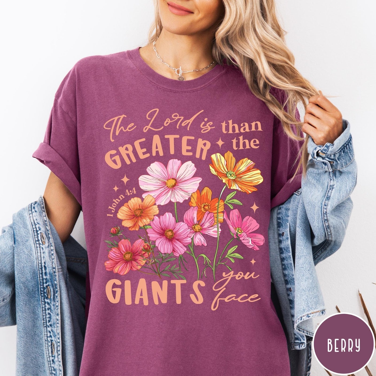 Comfort Colors tee in Berry featuring floral Bible verse graphic design with 1 John 4:4 scripture text
