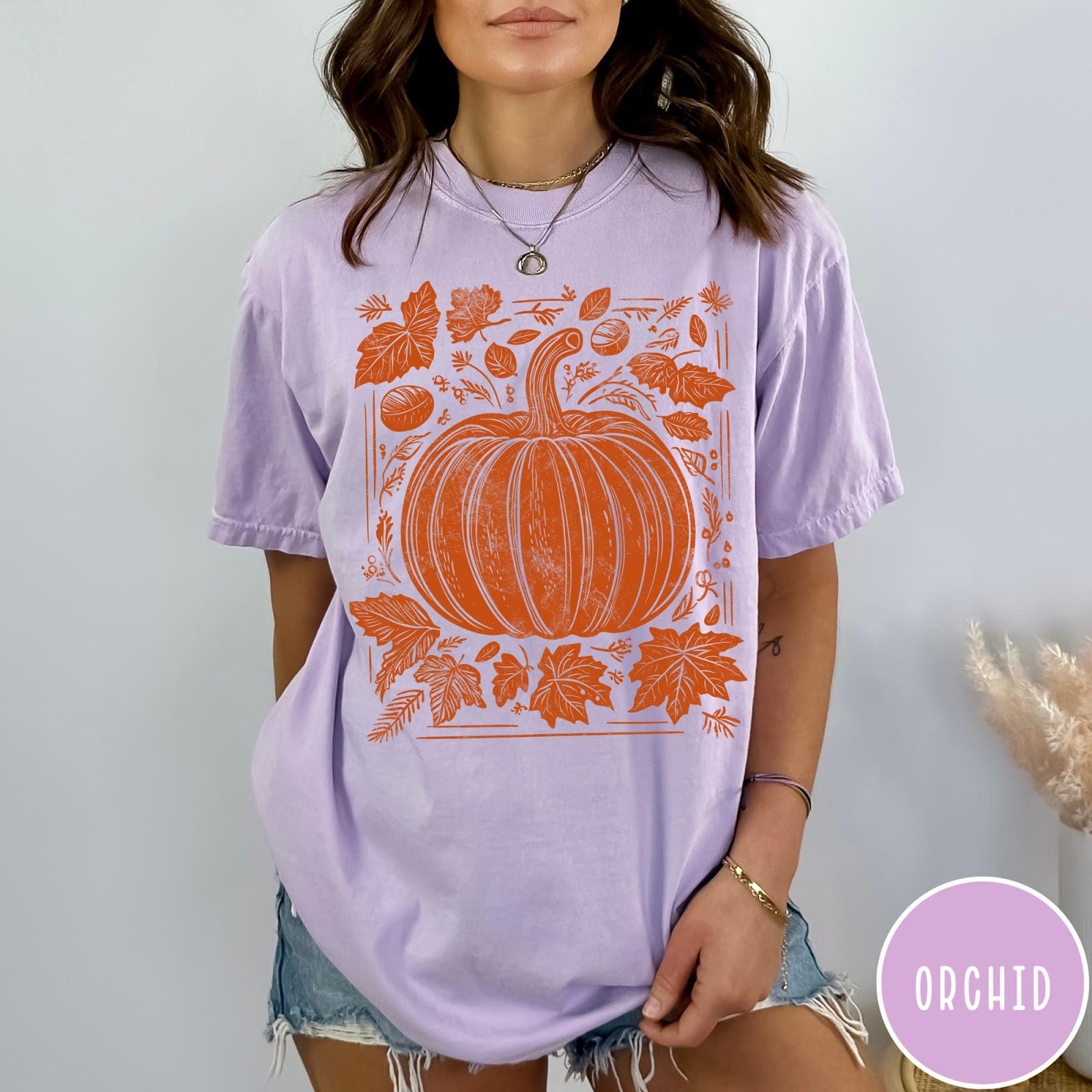Comfort Colors tee in Orchid featuring rustic pumpkin design with surrounding fall leaves and woodland elements