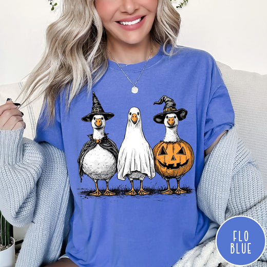 Comfort Colors tee in Flo Blue featuring Halloween graphic with three geese dressed as a witch, ghost, and pumpkin