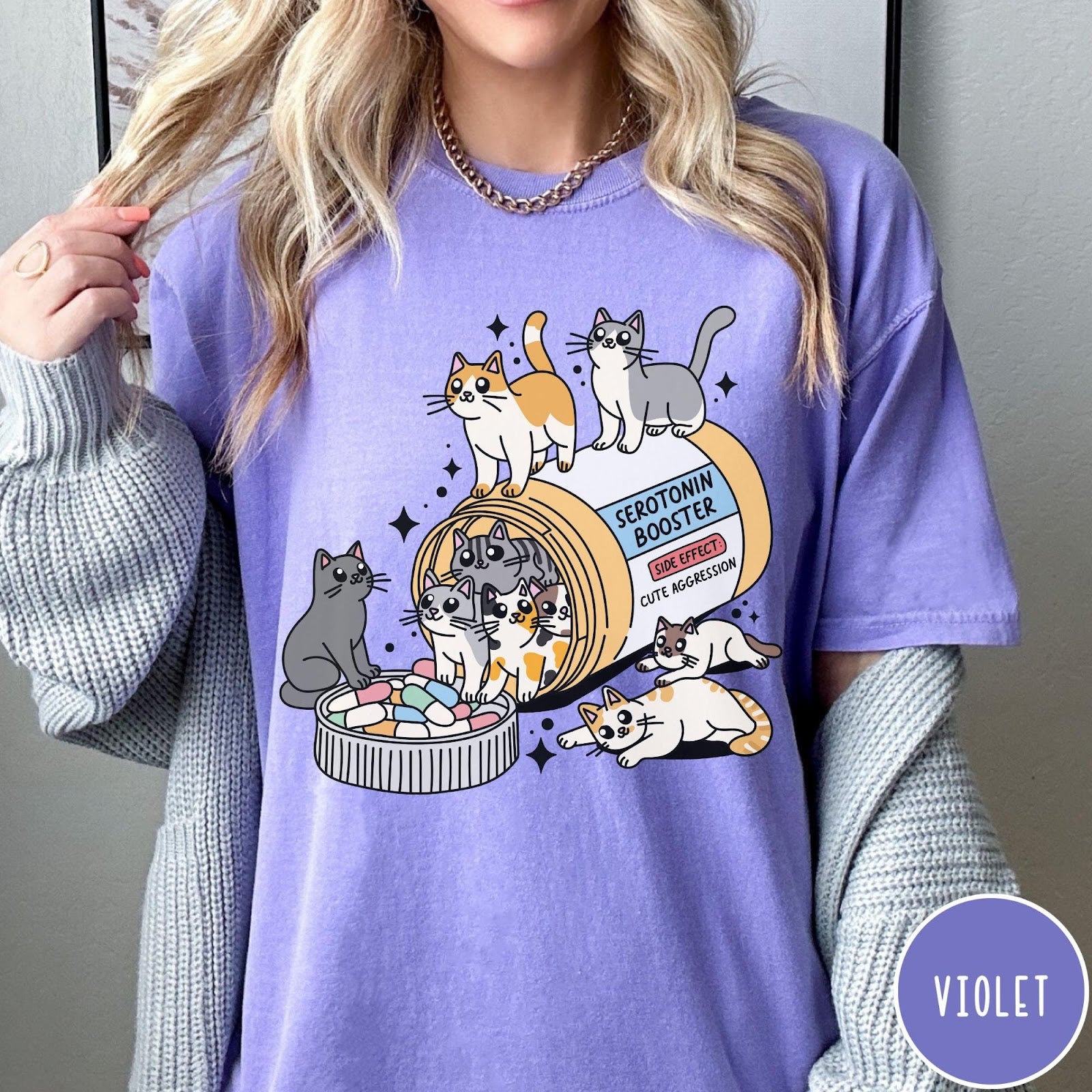 Comfort Colors tee in Violet featuring graphic illustration of cats spilling out of a serotonin booster bottle