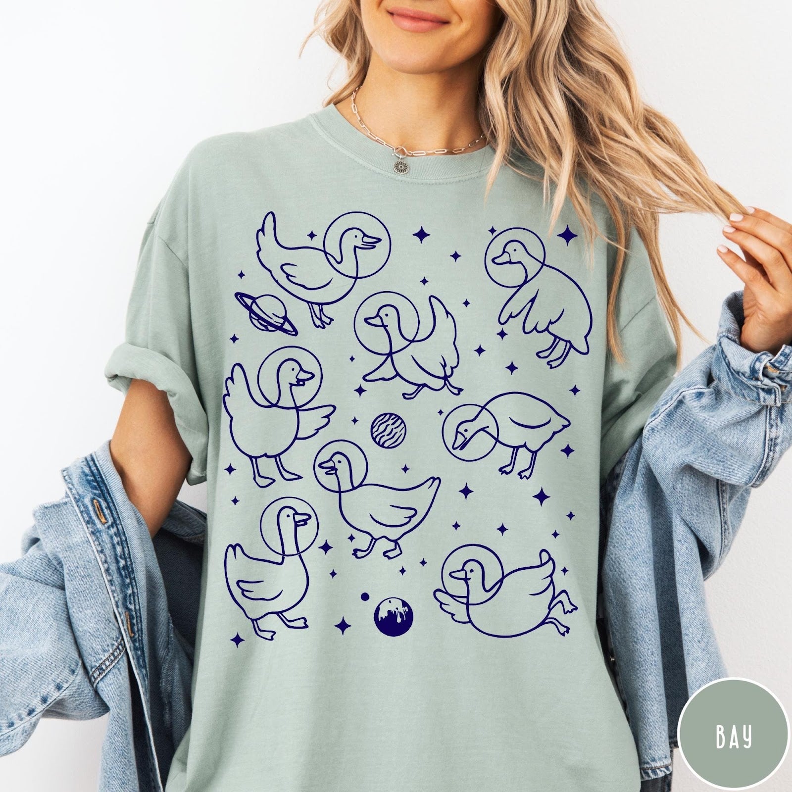 Comfort Colors tee in Bay featuring line art graphic of multiple geese wearing astronaut helmets in space