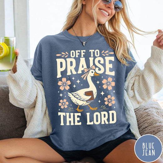 Comfort Colors tee in Blue Jean featuring retro style graphic of a goose wearing a bow holding a book