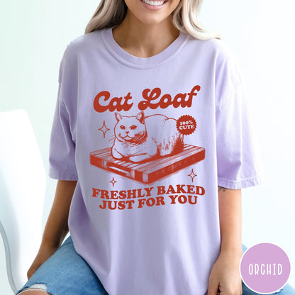 Comfort Colors tee in Orchid featuring graphic style cat loaf sitting on a wooden cutting board