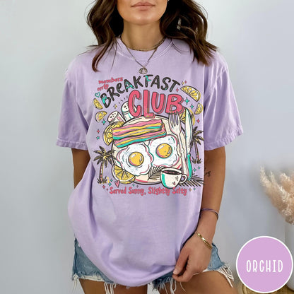 Comfort Colors tee in Orchid featuring breakfast food graphic with bacon, eggs, coffee, and palm trees.
