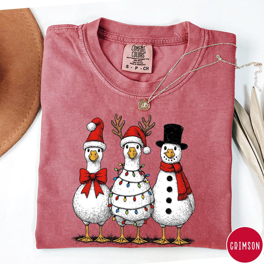 Comfort Colors tee in Crimson featuring festive holiday graphic of three geese dressed as Santa and snowman