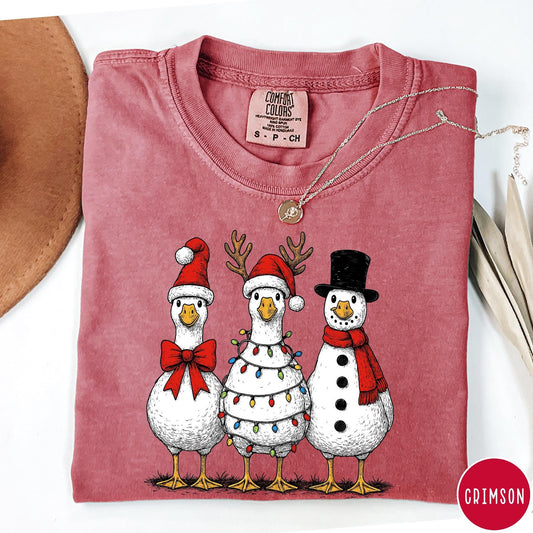 Comfort Colors tee in Crimson featuring festive holiday graphic of three geese dressed as Santa and snowman