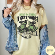 Comfort Colors tee in Butter featuring vintage style graphic of two frogs wearing cowboy hats on leaf