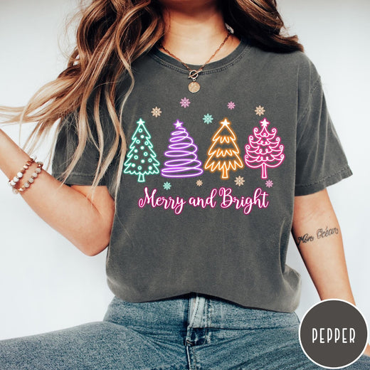 Comfort Colors tee in Pepper featuring neon Christmas tree graphic with Merry and Bright text and snowflakes