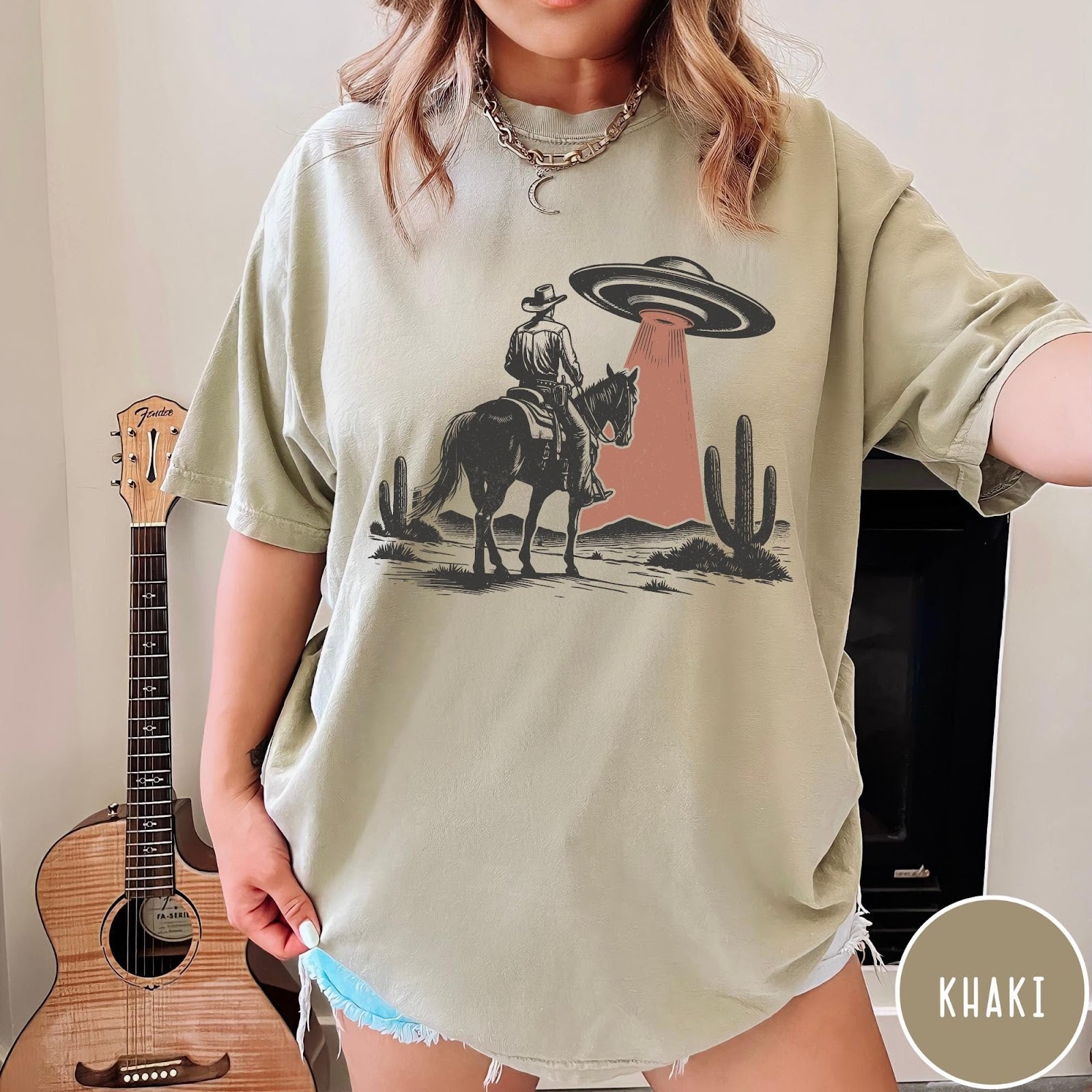 Comfort Colors tee in Khaki featuring western style graphic of a cowboy on horseback under a UFO