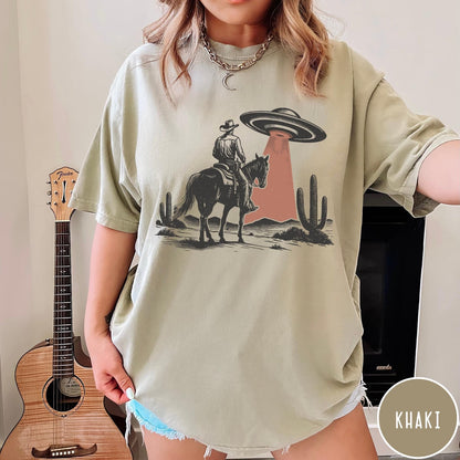 Comfort Colors tee in Khaki featuring western style graphic of a cowboy on horseback under a UFO