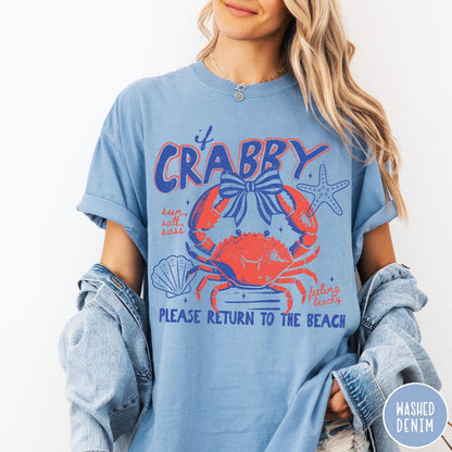 Comfort Colors tee in Washed Denim featuring coastal graphic design with a crab, bow, starfish, and beach text