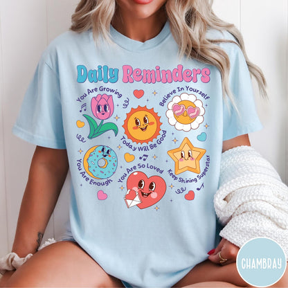 Comfort Colors tee in Chambray featuring retro mascot design with daily affirmations and colorful cartoon characters