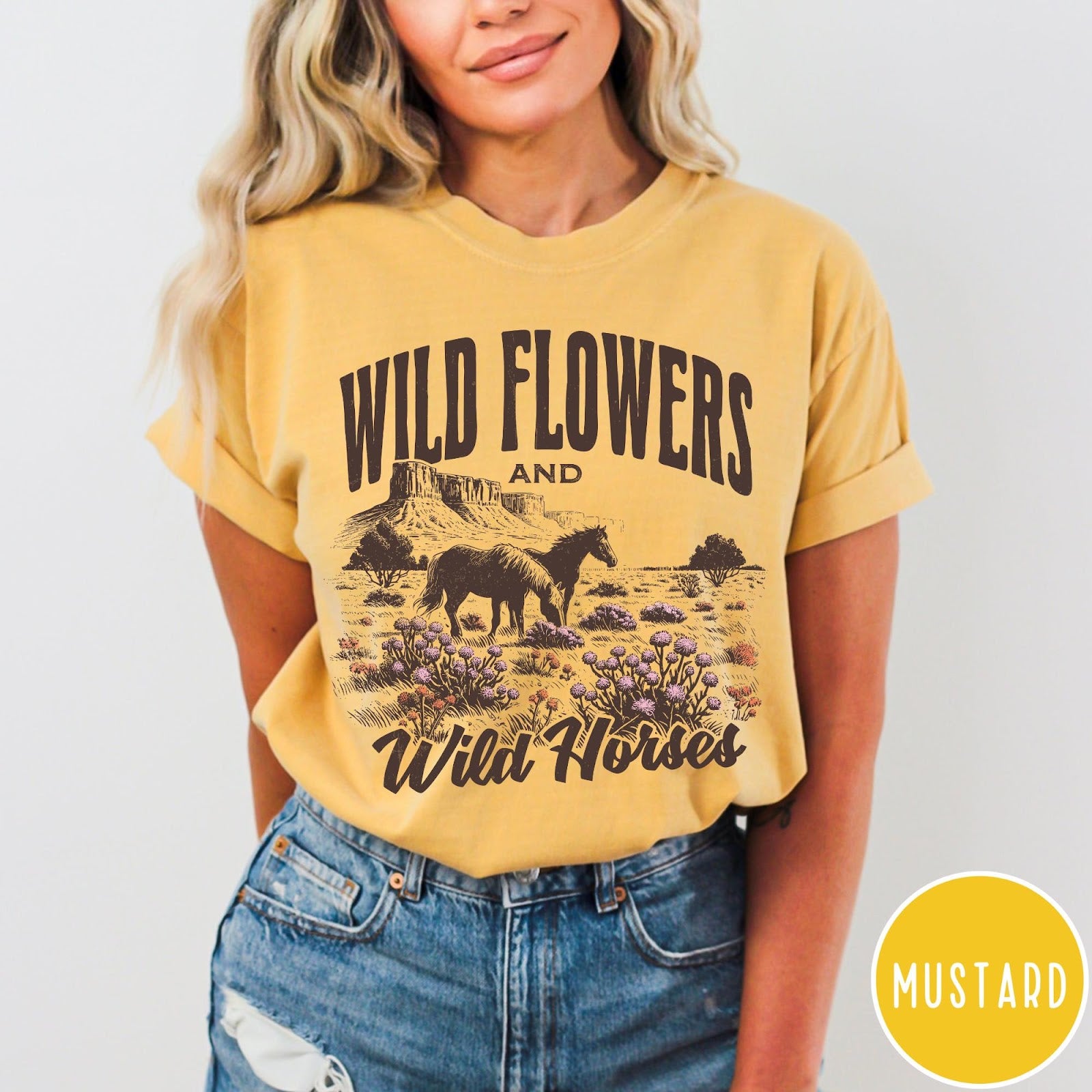Comfort Colors tee in Mustard featuring western style graphic of wild horses grazing in a wildflower field