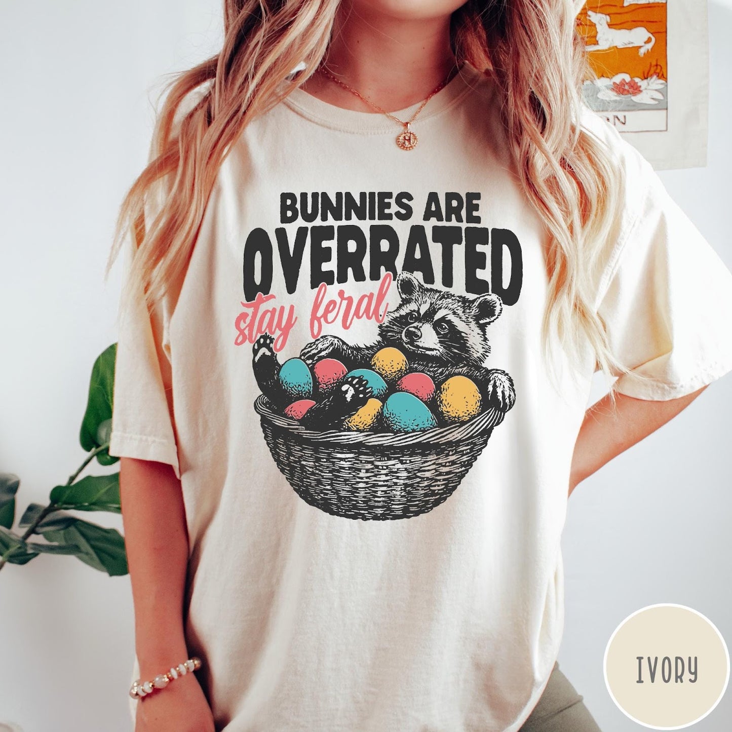Comfort Colors tee in Ivory featuring graphic illustration of a raccoon sitting in an Easter basket