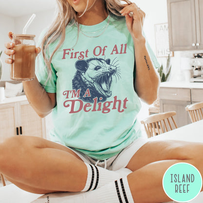 Comfort Colors tee in Island Reef featuring illustrative opossum graphic with text First Of All I'm A Delight